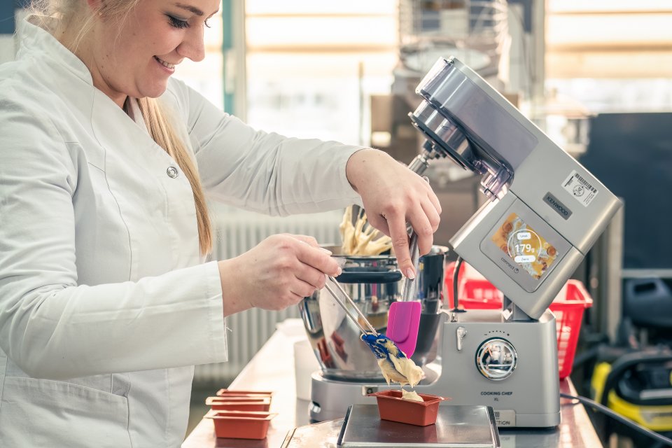 A woman fills a baking machine with bread dough.Image source: University of Hohenheim / Oliver Reuther | more press photos in print quality