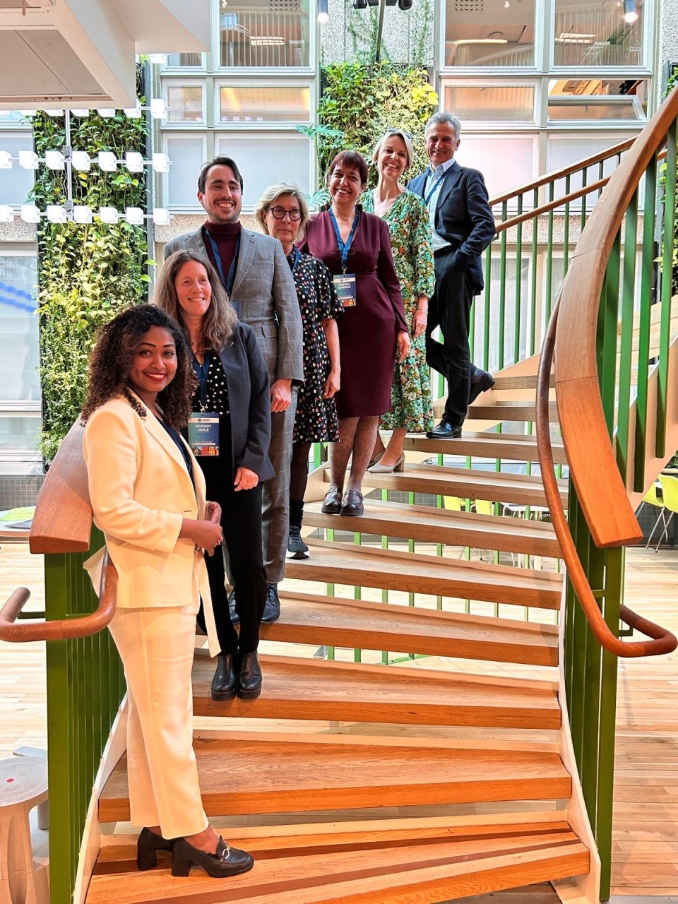 Several people are lined up on a staircase, having their picture taken.