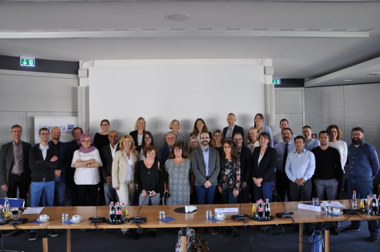 Eine Gruppe von Menschen reiht sich für ein Gruppenbild auf.