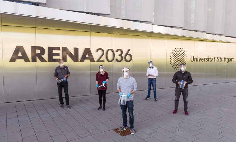 Ein fünfköpfiges Team steht vor Forschungsfabrik ARENA2036. Alle halten ein Schutzvisier in den Händen.