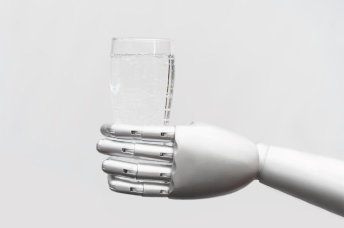 Eine Roboterhand hält ein Glas mit Wasser