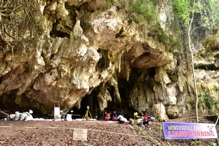 Eingang einer Höhle mit einer Gruppe forschender Menschen vor dem Eingang