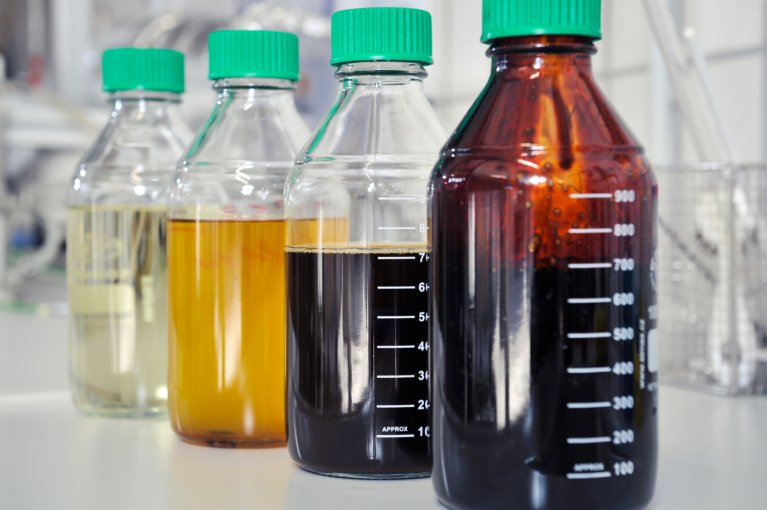 Verschiedene Flüssigkeiten in vier Laborflaschen