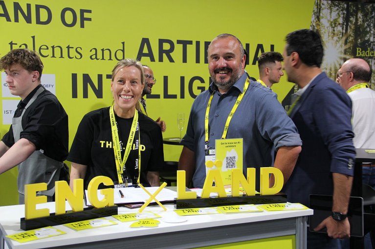 Links auf dem Bild ist Nicola Pinder (Repräsentantin des Landes Baden-Württemberg) zu sehen. Rechts sieht man Tony Corby (Sector Manager bei der Leeds City Region Enterprise Partnership). Beide stehen an einem Tisch mit ENG x LÄND Flyern
