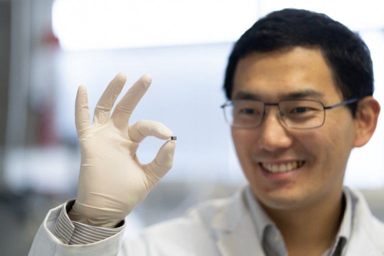 Rechts im Bild zu sehen ist Dr. Tian Qiu. Links im Fokus ist Dr. Tian Qius Hand in welcher er einen Mikro-Medizinroboter hält.