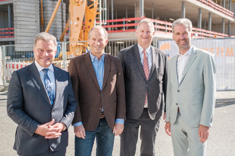 Gruppenbild vor der Baustelle des neuen Erweiterungsbaus im Technologiepark Tübingen. Von links nach rechts sind Christian Erbe, Dr. Dirk Biskup, Prof. Bernd Pichler und Boris Palmer zu sehen