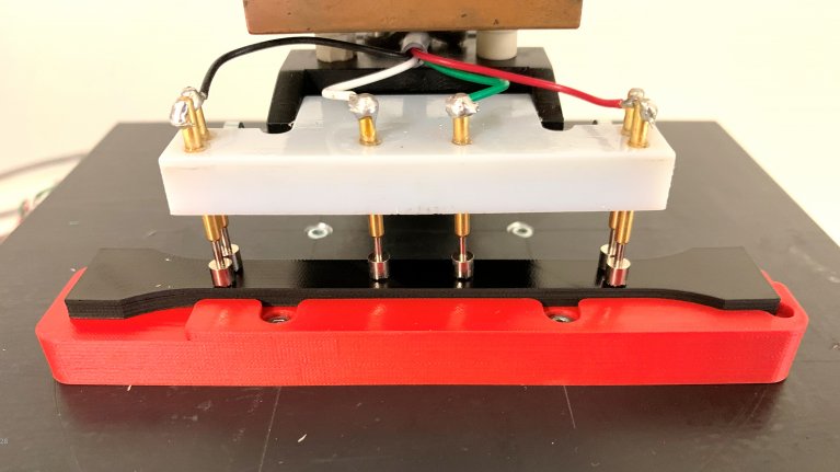 In der Mitte des Bildes ist ein thermoplastischer Elastomer mit Rußpartikeln zu sehen. Dieser wird einer Widerstandsmessung unterzogen.