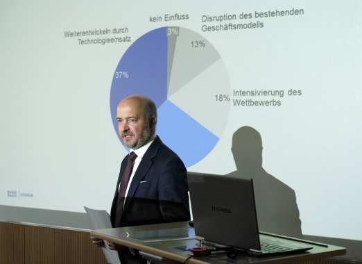 Carsten Lehberg steht vor einem Kreisdiagramm und wendet sich an das Publikum.
