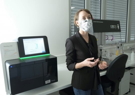 Dr. Silke Grumaz steht vor der Diagnostikplattform von Noscendo und erklärt die Technik.