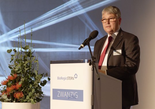 Klaus Eichenberg steht an einem Rednerpult und spricht in ein Mikrofon