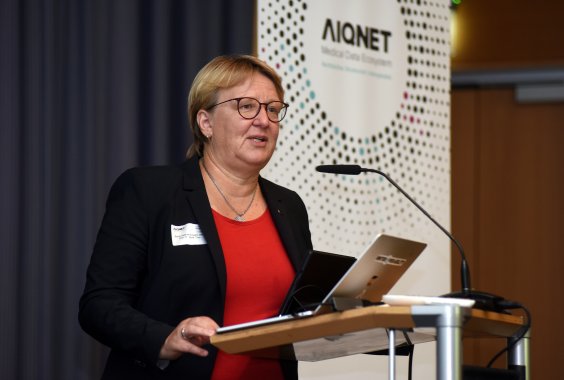 Prof. Dr. Sylvia Thun, Direktorin, steht am Pult und spricht in ein Mikrofon