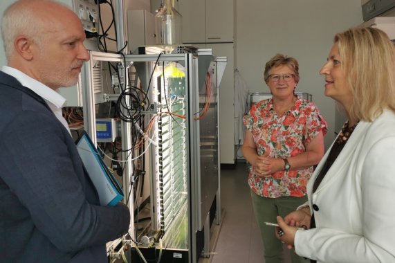 MD Michael Münter steht in einem Labor und unterhält sich mit zwei Frauen vom Fraunhofer Institut