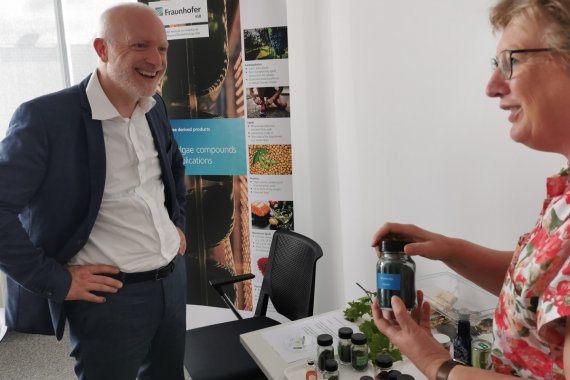 MD Dr. Michael Münter (Leiter des Umweltministeriums), links im Bild, unterhält sich mit einer Frau