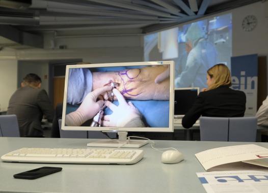 In the center of the picture is a computer with the live-streame of a knee oparation.
