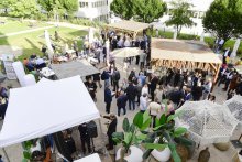 Blick von oben auf viele Personen die sich unterhalten